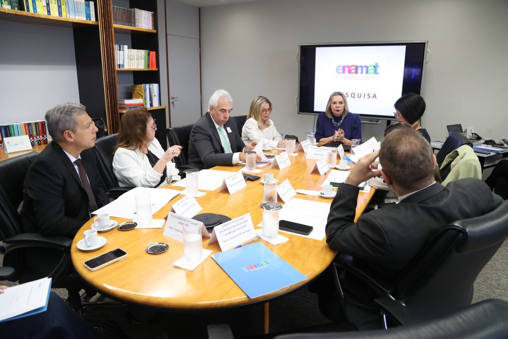 Fotografia da reunião com 7 pessoas em torno de uma pessoa oval