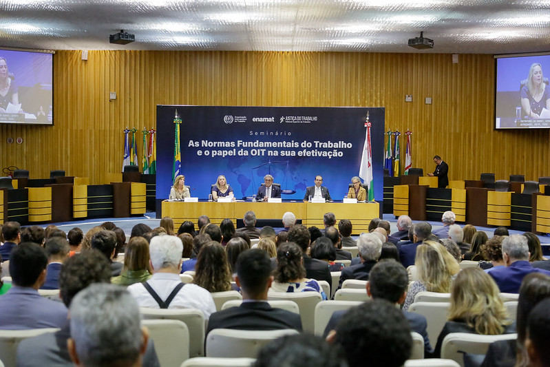 Foto do plenário com ministros e representantes da OIT na mesa.