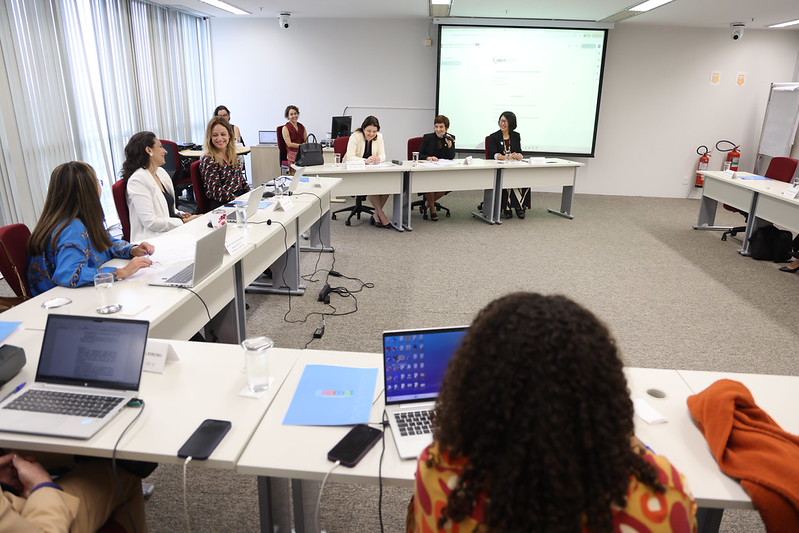 Foto da sala onde foi realizada a reunião. As mesas estão dispostas em 