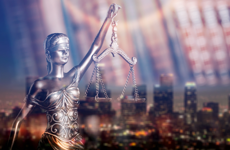 Ilustração com a estatua da justiça com uma cidade em reflexo ao fundo.